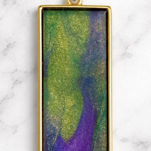 Green, purple, and gold marbleized polymer clay in a gold toned bezel